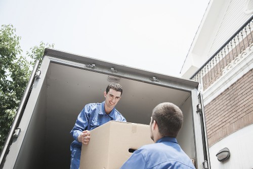Local removalists in Harrow carrying furniture through a residential street